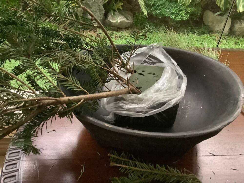 Longer branches are stuck at the base of the foam to start the arrangement. Longer branches are stuck at the base of the foam to start the arrangement.